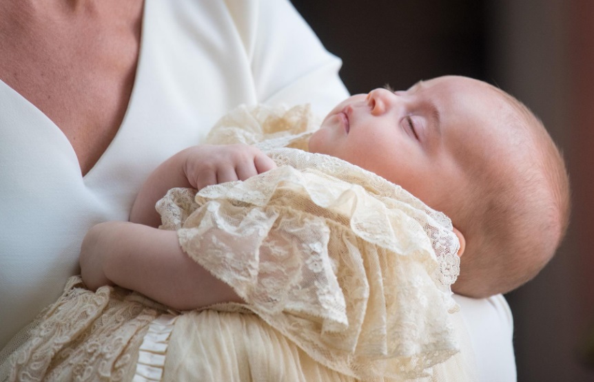 Un bébé en tenue de baptême