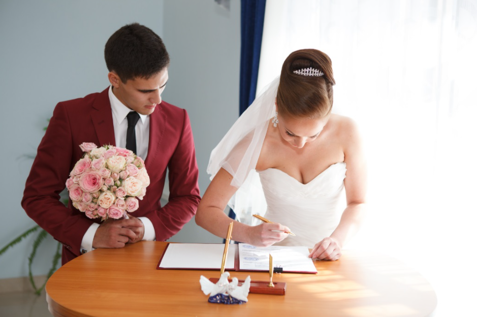 Un couple signant son contrat de mariage